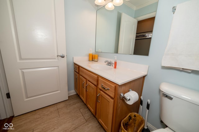 bathroom with vanity, ornamental molding, and toilet