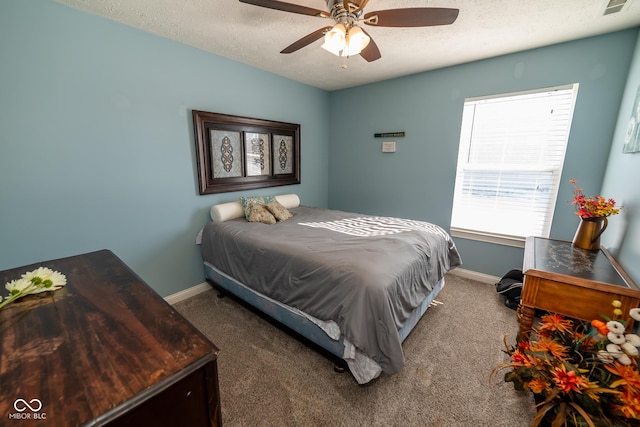 carpeted bedroom featuring ceiling fan and a textured ceiling