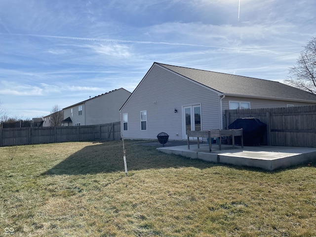 rear view of house featuring french doors, a patio, and a lawn