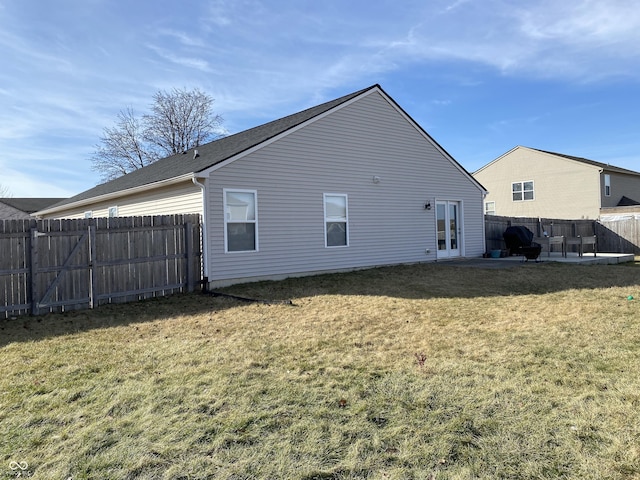 back of house featuring a lawn, french doors, and a patio area