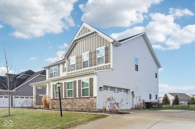 view of front of house featuring a garage, central AC, and a front lawn