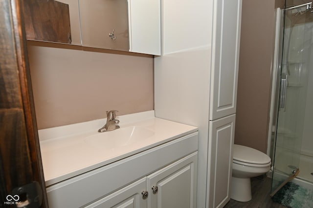 full bath featuring vanity, a shower stall, toilet, and wood finished floors