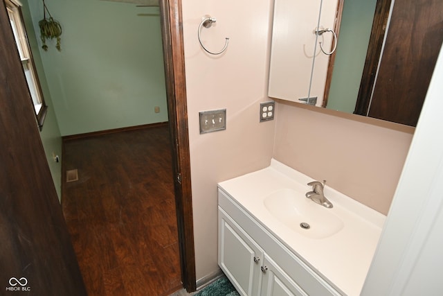 bathroom featuring vanity, baseboards, and wood finished floors