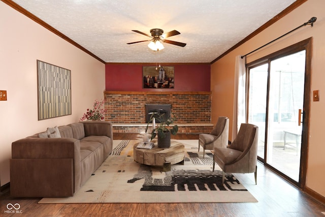 living area with a ceiling fan, crown molding, wood finished floors, and a textured ceiling