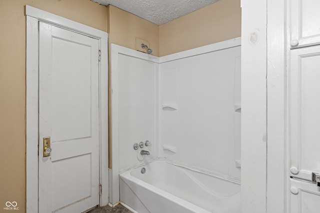 bathroom featuring shower / washtub combination and a textured ceiling