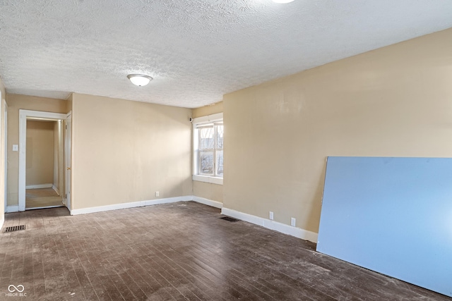 unfurnished room with hardwood / wood-style floors and a textured ceiling