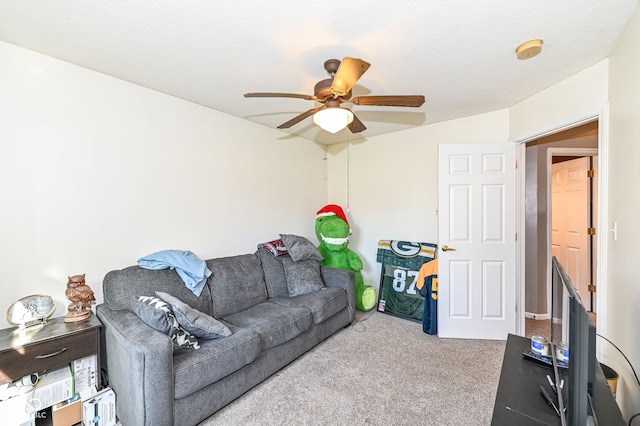 living room featuring ceiling fan, light colored carpet, and a textured ceiling