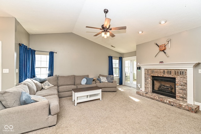 living room featuring ceiling fan, lofted ceiling, a fireplace, and carpet floors