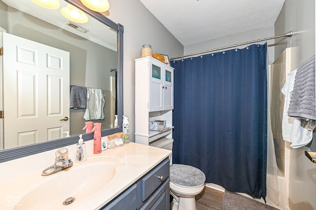 full bathroom with hardwood / wood-style flooring, vanity, a textured ceiling, toilet, and shower / bath combo with shower curtain