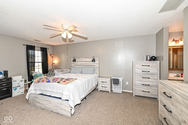 carpeted bedroom featuring ceiling fan and a textured ceiling