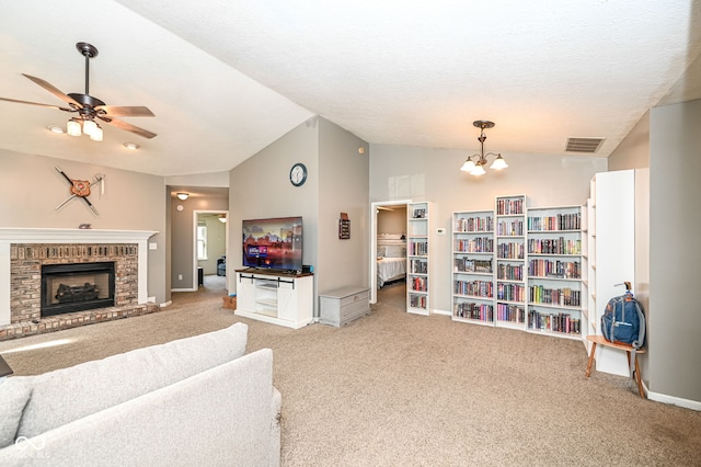 living room featuring vaulted ceiling, a brick fireplace, light carpet, a textured ceiling, and ceiling fan with notable chandelier