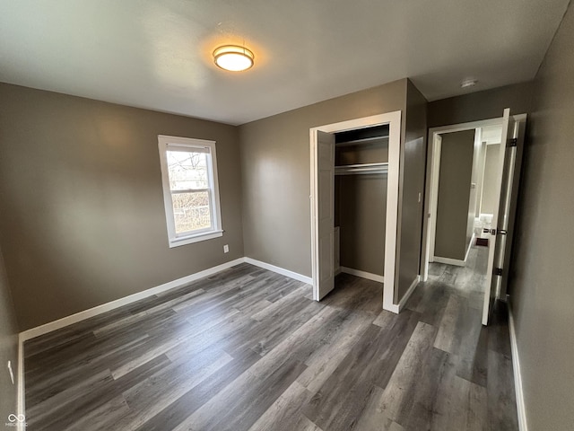 unfurnished bedroom featuring dark wood-type flooring and a closet