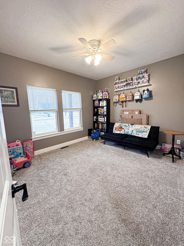 interior space featuring a textured ceiling, carpet floors, and ceiling fan