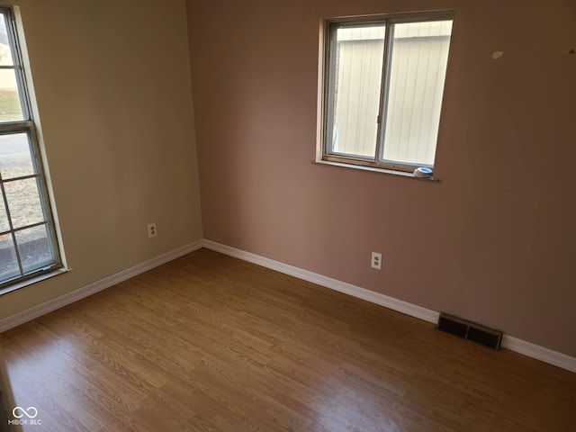 unfurnished room with hardwood / wood-style flooring