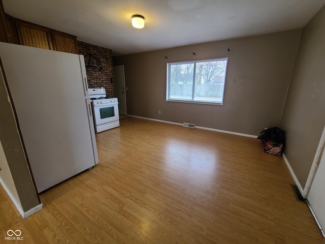 kitchen with white appliances and light hardwood / wood-style floors