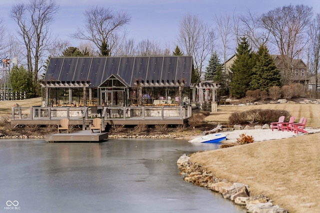 back of property featuring a deck with water view