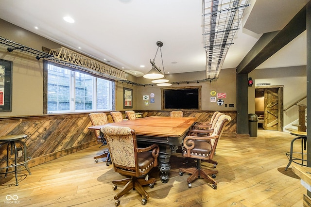 dining room featuring wooden walls and light wood-type flooring