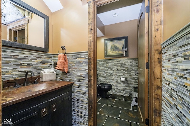 bathroom with tile patterned floors, vanity, toilet, and tile walls