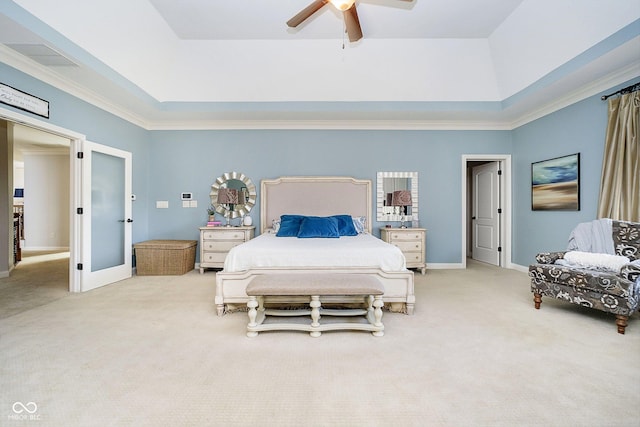 carpeted bedroom with crown molding, a tray ceiling, and ceiling fan