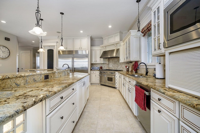 kitchen featuring sink, white cabinetry, built in appliances, ventilation hood, and decorative light fixtures