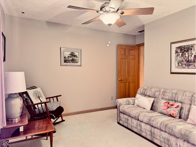 carpeted living room with ceiling fan and a textured ceiling