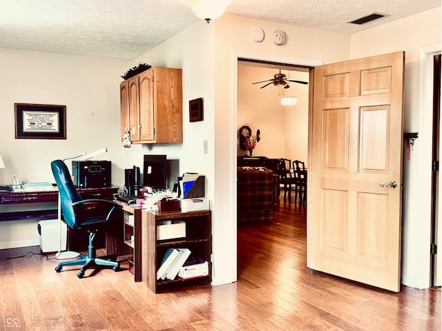 office area featuring ceiling fan, a textured ceiling, and light wood-type flooring