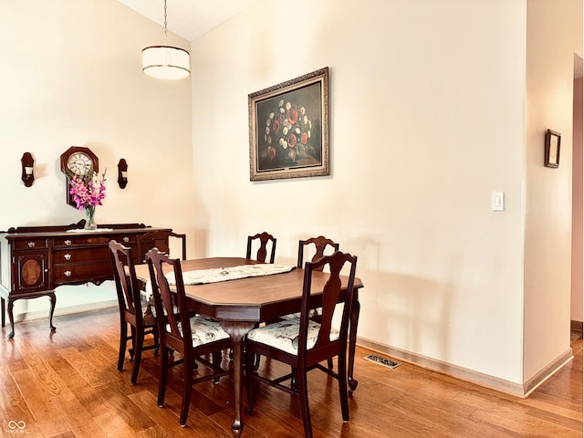 dining space with vaulted ceiling and light wood-type flooring