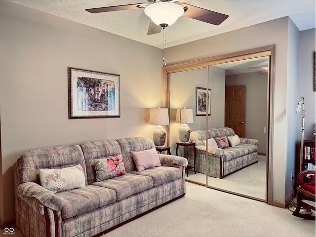 living room featuring light carpet, a textured ceiling, and ceiling fan