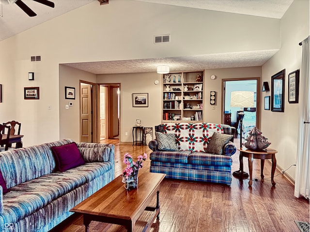 living room with ceiling fan, high vaulted ceiling, hardwood / wood-style floors, and a textured ceiling