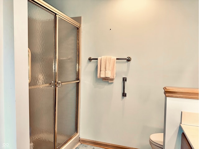 bathroom with vanity, an enclosed shower, and toilet