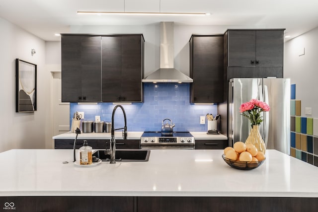 kitchen featuring a kitchen island with sink, tasteful backsplash, stainless steel appliances, and wall chimney exhaust hood