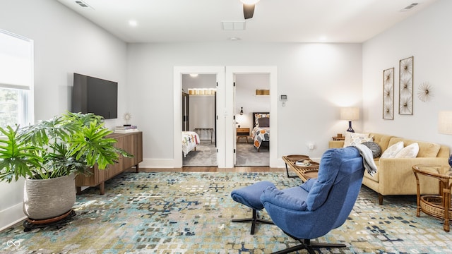 living room with hardwood / wood-style flooring, ceiling fan, and french doors