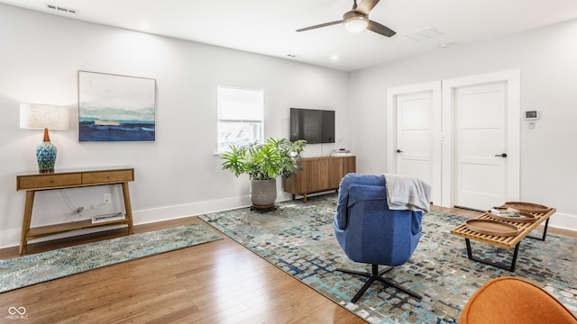 living room featuring wood-type flooring and ceiling fan