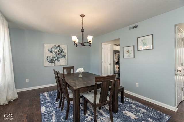 dining room featuring a chandelier, visible vents, dark wood finished floors, and baseboards