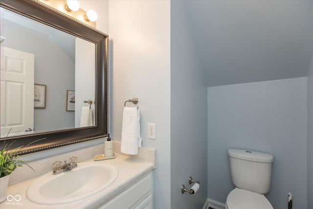 bathroom with vanity, lofted ceiling, and toilet