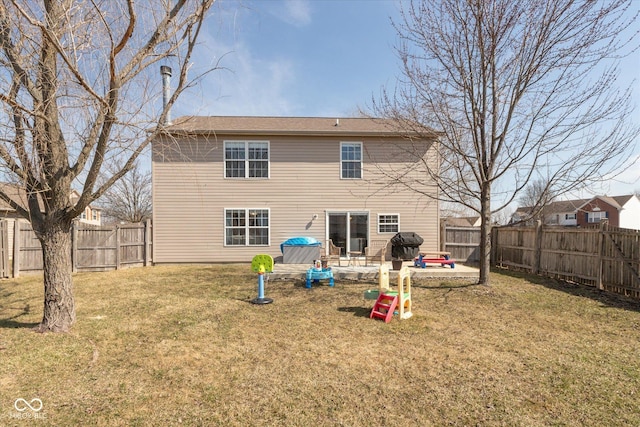 rear view of house with a patio, a lawn, and a fenced backyard