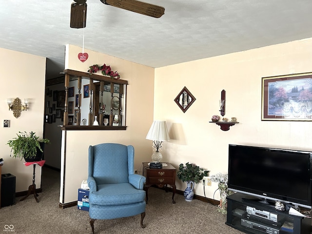 living area with ceiling fan and carpet