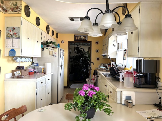 kitchen featuring white fridge and cream cabinetry