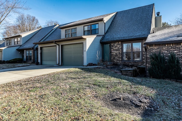 view of property with a garage and a front lawn