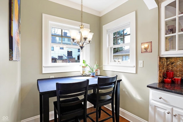 dining room featuring a chandelier, plenty of natural light, and baseboards