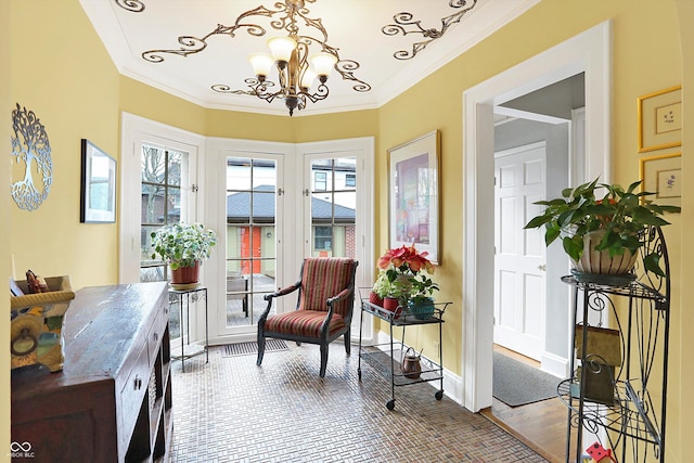 living area with a notable chandelier, crown molding, baseboards, and wood finished floors