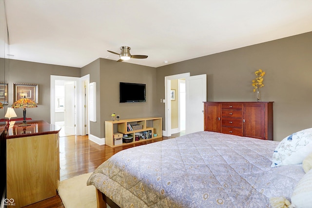 bedroom with a ceiling fan, baseboards, and wood finished floors