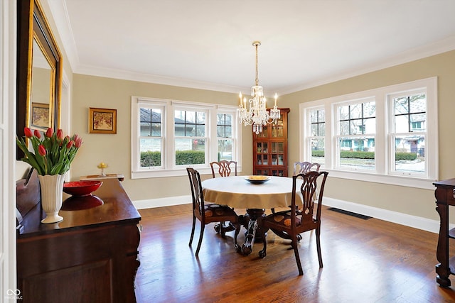 dining area with plenty of natural light, visible vents, dark wood-type flooring, and crown molding