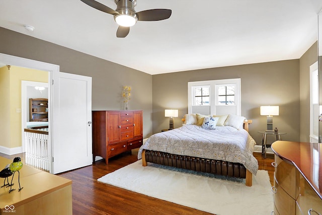 bedroom featuring a ceiling fan, a baseboard radiator, dark wood finished floors, and baseboards