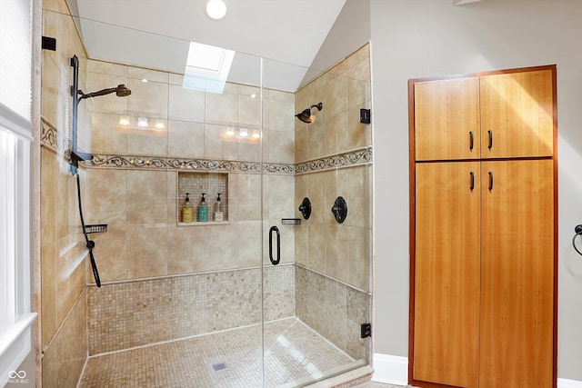 full bathroom with lofted ceiling with skylight and a stall shower