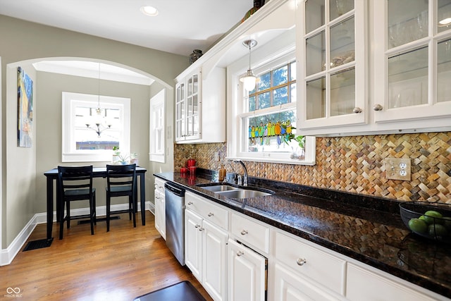 kitchen with white cabinets, a sink, hanging light fixtures, and dishwasher