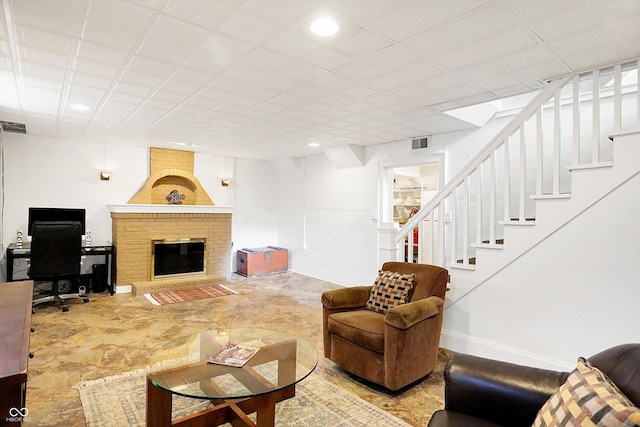 living room with baseboards, visible vents, stairway, a brick fireplace, and recessed lighting