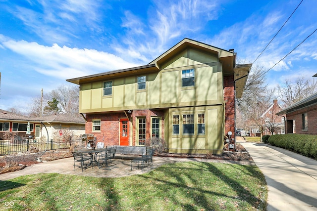 back of property with a patio, brick siding, fence, a lawn, and stucco siding