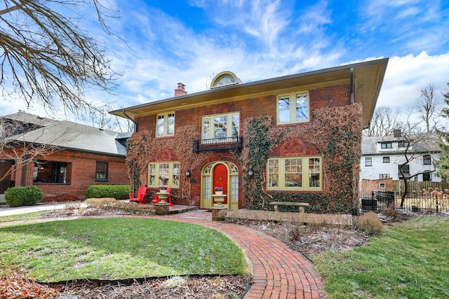 view of front of property featuring brick siding, fence, a chimney, and a front lawn