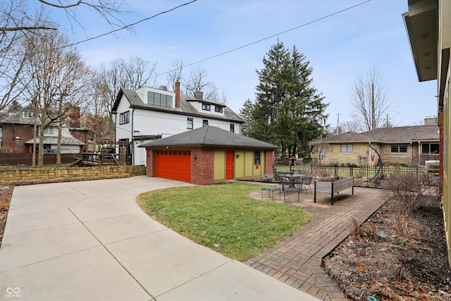 view of front of home with driveway, an outbuilding, fence, a front lawn, and brick siding